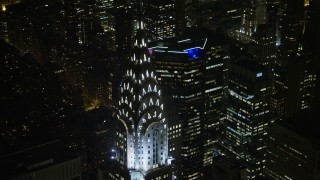 AX0065_0319E - 5K aerial stock footage tilt from the top of the Chrysler Building to reveal Empire State Building and Midtown Manhattan, New York City, winter, night