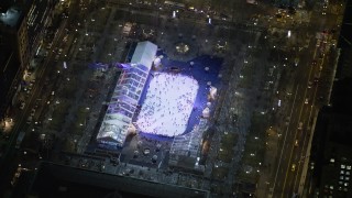 AX0065_0329E - 5K stock footage aerial video orbit a skyscraper to reveal the ice skating rink at Bryant Park in Midtown Manhattan, New York City, winter, night