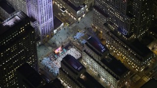 AX0065_0335E - 5K stock footage aerial video orbit Rockefeller Center skyscraper to reveal the ice skating rink, Midtown Manhattan, New York City, winter, night