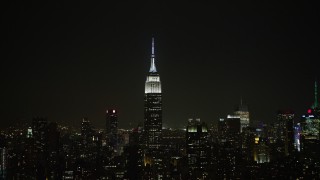 AX0065_0365 - 5K aerial stock footage of the Empire State Building and Midtown Manhattan skyscrapers, New York City, winter, night