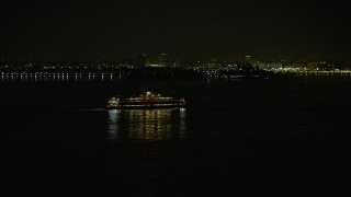 AX0065_0385 - 5K aerial stock footage of Staten Island Ferry sailing New York Harbor, winter, night