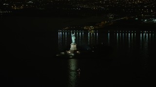 AX0065_0388E - 5K aerial stock footage of Statue of Liberty monument on Liberty Island in New York, winter, night