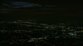 AX0156_002 - 7.6K stock footage aerial video passing suburban neighborhoods at night in Burbank, California