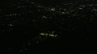 AX0156_011E - 7.6K aerial stock footage orbiting the Griffith Observatory at night with a view of Hollywood in Los Angeles, California