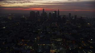 AX0156_043 - 7.6K stock footage aerial video tilting from MacArthur Park to reveal Downtown Los Angeles skyline at sunrise, California
