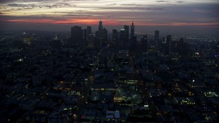 AX0156_043E - 7.6K aerial stock footage tilting from MacArthur Park to reveal Downtown Los Angeles skyline at sunrise, California