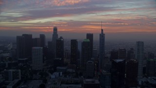 AX0156_075 - 7.6K aerial stock footage flying between skyscrapers in Downtown Los Angeles, California, revealing City Hall early in the morning