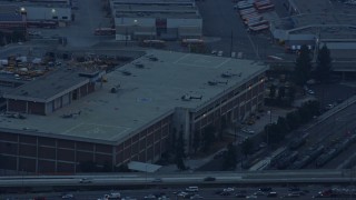 AX0156_088 - 7.6K aerial stock footage of Police Helicopters on a LAPD building in Downtown Los Angeles, California at sunrise