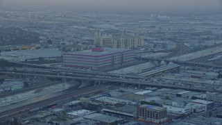 AX0156_104 - 7.6K aerial stock footage of office building and heavy traffic on I-10 in Downtown Los Angeles, California at sunrise