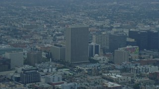 AX0156_107E - 7.6K aerial stock footage of office buildings and the Equitable Life Building in Koreatown, Los Angeles, California at sunrise