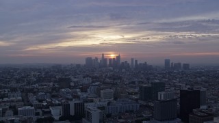 AX0156_110 - 7.6K stock footage aerial video flying over Koreatown office buildings to approach the skyline of Downtown Los Angeles, California at sunrise