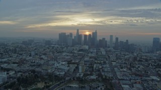 AX0156_110E - 7.6K aerial stock footage flying over Koreatown office buildings to approach the skyline of Downtown Los Angeles, California at sunrise