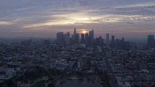 AX0156_111 - 7.6K stock footage aerial video approaching the skyline of Downtown Los Angeles, California at sunrise, fly over MacArthur Park