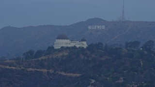 AX0156_119 - 7.6K aerial stock footage approaching Griffith Observatory with the Hollywood Sign in the background at sunrise, Los Angeles, California