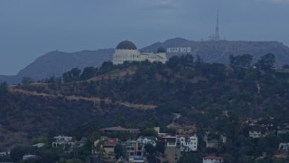 AX0156_120 - 7.6K aerial stock footage flying by Griffith Observatory to reveal the Hollywood Sign at sunrise, Los Angeles, California