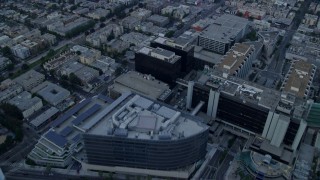 AX0156_121 - 7.6K aerial stock footage flying over mansions to approach Beverly Center and Cedars-Sinai Medical Center at sunrise in Beverly Hills, California