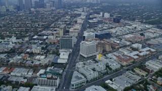 AX0156_130 - 7.6K aerial stock footage flying over Wilshire Boulevard towards Santa Monica Blvd, near Century City, sunrise, Beverly Hills, California