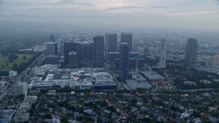 AX0156_133E - 7.6K aerial stock footage passing by a shopping mall set against office buildings, sunrise, Century City, California