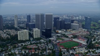 AX0156_136E - 7.6K aerial stock footage of condominiums and skyscrapers near Beverly Hills High School, sunrise, Century City, California