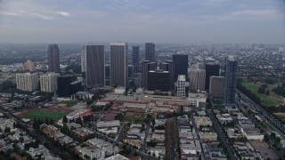AX0156_137 - 7.6K stock footage aerial video orbiting away from skyscrapers and Beverly Hills High School, sunrise, Century City, California