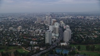 AX0156_138 - 7.6K stock footage aerial video following Wilshire Blvd over Los Angeles Country Club and The Windmill Links, sunrise, Century City, Beverly Hills, California