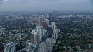 AX0156_138E - 7.6K aerial stock footage following Wilshire Blvd over Los Angeles Country Club and The Windmill Links, sunrise, Century City, Beverly Hills, California