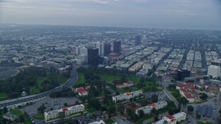 AX0156_141E - 7.6K aerial stock footage flying over Interstate 405 and apartment buildings following Wilshire Boulevard, sunrise, Sawtelle, California