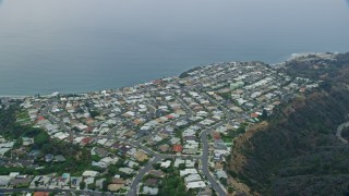 AX0156_163E - 7.6K aerial stock footage flying by and orbiting homes overlooking the ocean in the morning in Pacific Palisades, California