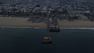 AX0156_169E - 7.6K aerial stock footage of Santa Monica Pier, seen from the ocean at sunrise, Santa Monica, California