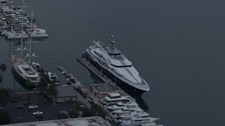 AX0156_176 - 7.6K aerial stock footage of a mega yacht docked in harbor with helicopter on back, sunrise, Marina Del Rey, California