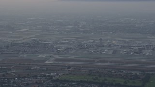 AX0156_179E - 7.6K aerial stock footage of LAX in a thick cloud covering, sunrise, Los Angeles, California