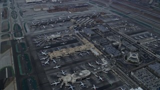 AX0156_181E - 7.6K aerial stock footage flying over LAX and parked airplanes, sunrise, Los Angeles, California