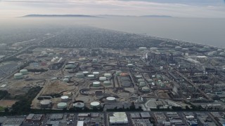 AX0156_185 - 7.6K aerial stock footage of Oil Refineries on a cloudy day, El Segundo, California