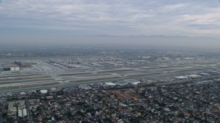 AX0156_189 - 7.6K aerial stock footage of a sideview of LAX on a cloudy morning, sunrise, Los Angeles, California
