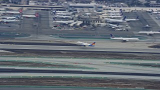 AX0156_191 - 7.6K aerial stock footage tracking a jet taking off from LAX in the morning, California