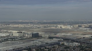 AX0157_002E - 7.6K aerial stock footage approaching LAX on a cloudy day, Los Angeles, California