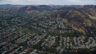 AX0157_036E - 7.6K aerial stock footage passing neighborhoods with tract homes in West Hills, California