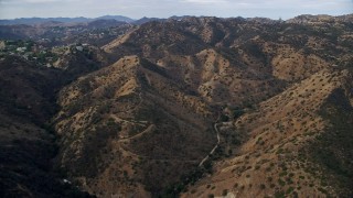 AX0157_038E - 7.6K aerial stock footage flying over brown hills and trees, Canoga park, California