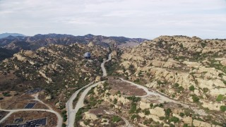 AX0157_040 - 7.6K stock footage aerial video flying over road leading to Aerojet Rocektdyne testing facility,  Brandeis, CA