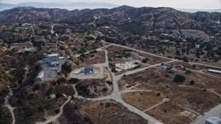 AX0157_050 - 7.6K stock footage aerial video flying over buildings at the Rocektdyne aerospace testing facility in Brandeis, CA