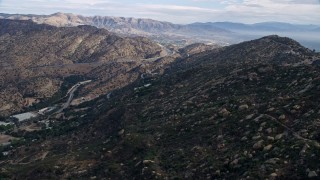 AX0157_053E - 7.6K aerial stock footage flying over Simi Valley hills towards San Fernando Valley, California