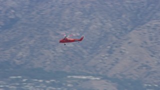 AX0157_086 - 7.6K aerial stock footage tracking a Sikorsky S58T flying by mountains in Pacoima, California