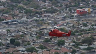 AX0157_087 - 7.6K aerial stock footage tracking a Sikorsky S58T flying over Pacoima, California