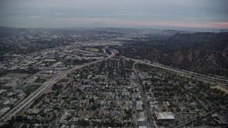 AX0158_003 - 7.6K aerial stock footage flying towards the I-5 & 134 interchange at twilight, Glendale, California