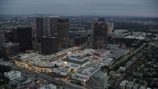AX0158_025 - 7.6K aerial stock footage passing by office buildings and shopping mall, twilight, Century City, California