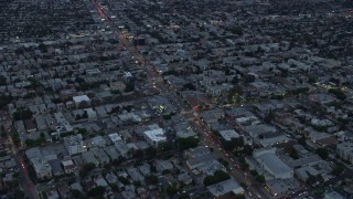 AX0158_037E - 7.6K aerial stock footage flying over businesses and neighborhoods along La Cienega Boulevard and West Pico Blvd, twilight, Central Los Angeles, California
