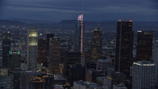 AX0158_047E - 7.6K aerial stock footage of Wilshire Grand Center and nearby skyscrapers at twilight in Downtown Los Angeles, California
