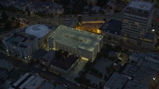 AX0158_055 - 7.6K aerial stock footage of a reverse view of the Angelus Temple and a parking garage at twilight in Echo Park, Los Angeles, California