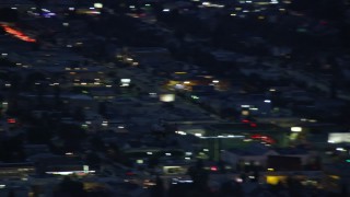 AX0158_062E - 7.6K aerial stock footage of an LAPD helicopter flying over city buildings at twilight in Los Angeles, California