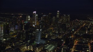 AX0158_093E - 7.6K aerial stock footage of skyscrapers at night in Downtown Los Angeles, California, seen from south of downtown